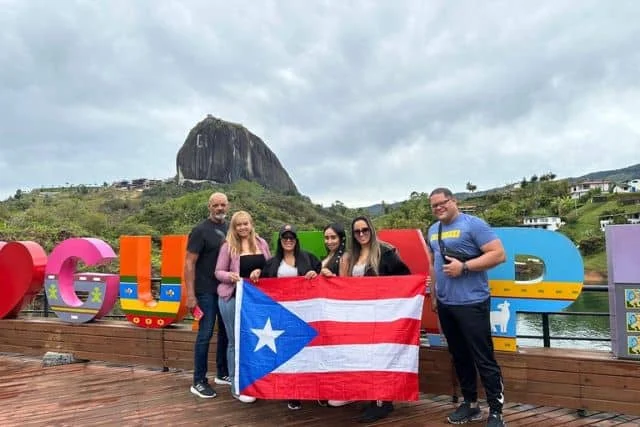 Grupo de viajeros frente al paisaje de Guatapé